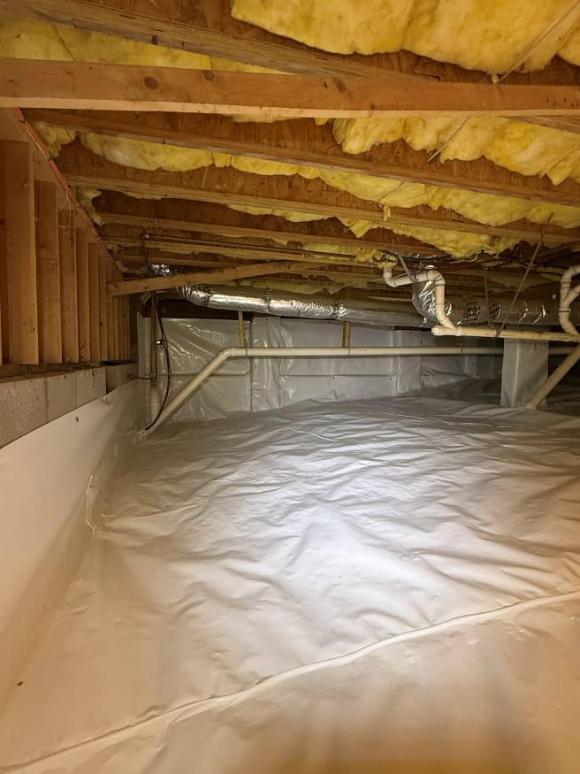 Crawl Space Encapsulation with Insulation and Exposed Ductwork in Wooden Framed crawl space