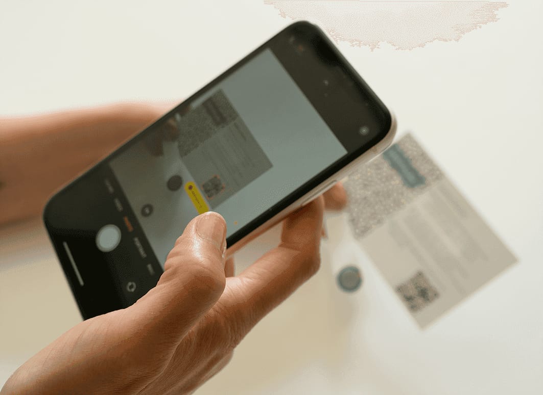 Person Scanning QR Code on Document with Smartphone in Well-Lit Setting