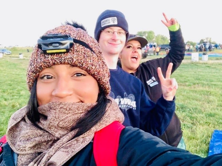 Joyful Group Selfie Outdoors with Knit Hats and Peace Signs in a Grassy Field Setting