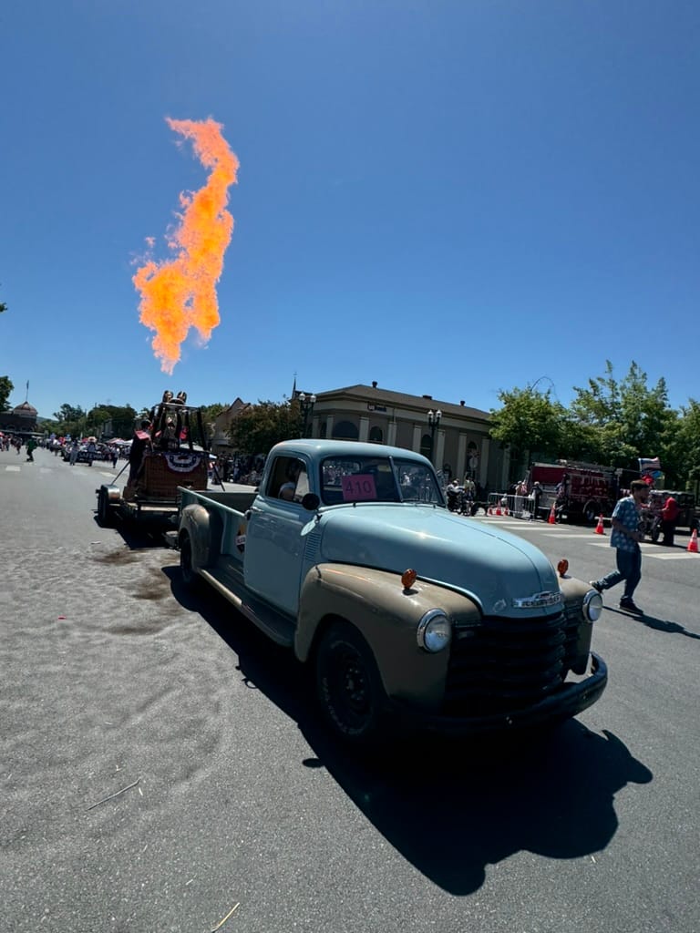 Vintage Truck Parade with Dramatic Flame Display on a Sunny Day