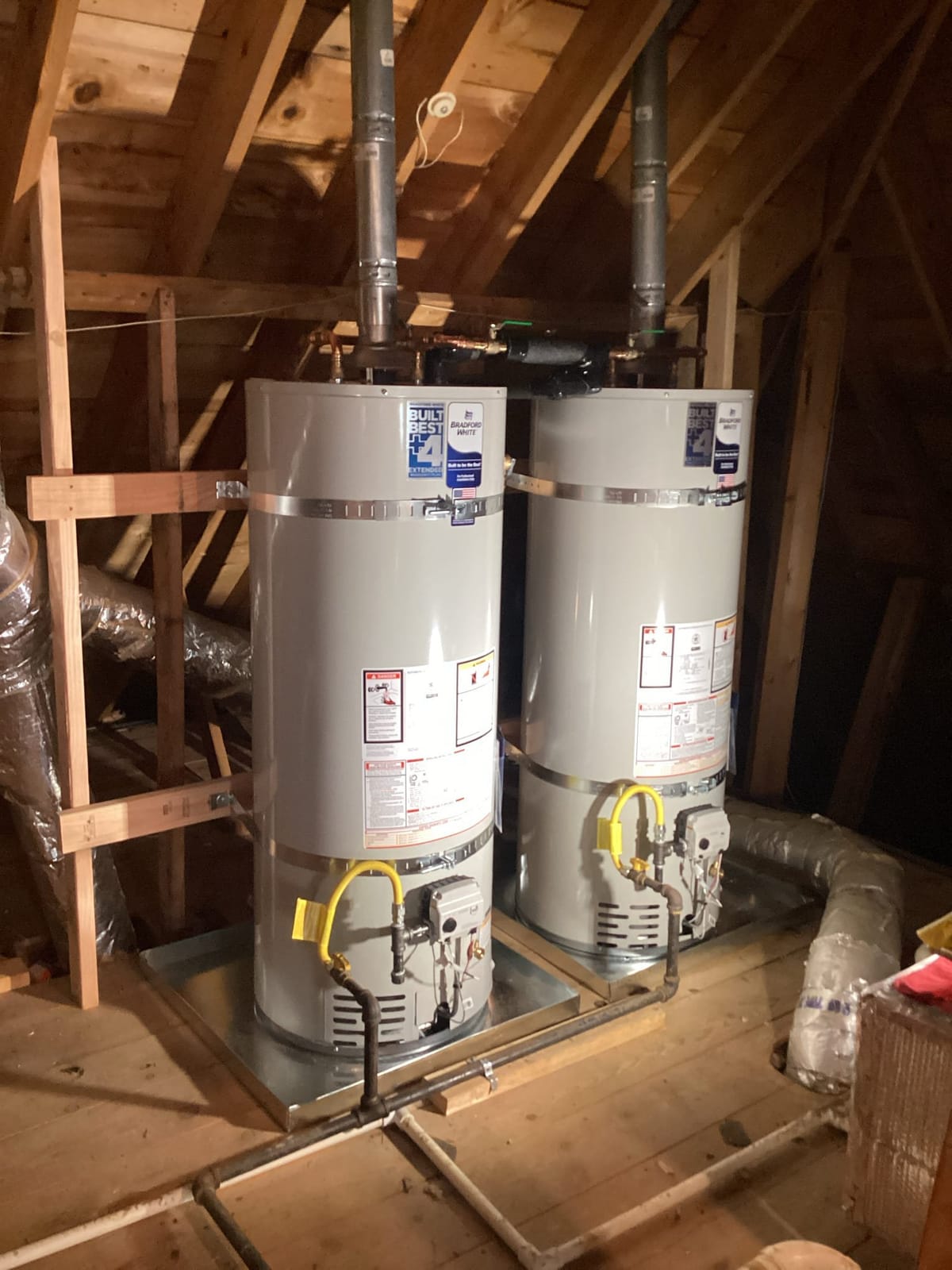 Dual Water Heaters in Attic with Exposed Wooden Beams and Ventilation Ducts