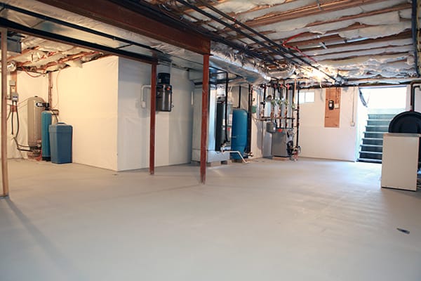 Spacious Unfinished Basement with Exposed Ceiling and Utility Equipment Featuring Water Heater and Blue Pressure Tank Adjacent to Staircase.